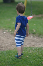 toddler boy in blue romper with white stripes on bottom back picture taken 
