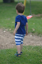 toddler boy in blue romper with white stripes on bottom back picture taken