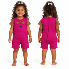 A toddler shown front and back wearing a bright pink sleeveless romper with brown short sleeves and a bear face graphic on the chest. The back view shows a full-length zipper.