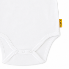 Close-up of a white baby bodysuit with three snap buttons at the crotch and a small yellow Toffoli brand tag on the side seam, set against a plain white background.