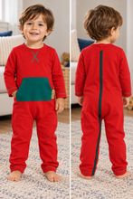 A toddler modeling a red one-piece footed pajama or romper with a large green front pocket and a green X-shaped zipper detail at the chest, shown in front and back views on a split background.