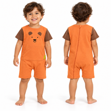 A toddler shown from the front and back wearing an orange short-sleeve romper with brown shoulder panels and a brown bear face graphic on the chest. The romper includes a front pocket and a zip closure at the back, photographed on a clean white background.