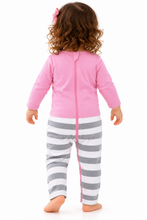 A toddler girl seen from the back, wearing a pink long-sleeve zip-front romper with gray and white horizontal striped pants, standing against a plain white background.