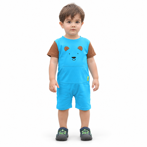 A toddler standing against a plain white background wearing a bright blue short-sleeve romper-style outfit with brown sleeves, a bear face graphic on the chest, and matching blue shorts.