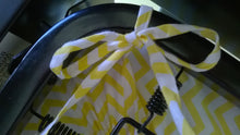 Fitted Crib Sheet with Ties -shows tied sheet ties around metal frame under the mattress in white with yellow chevron stripes